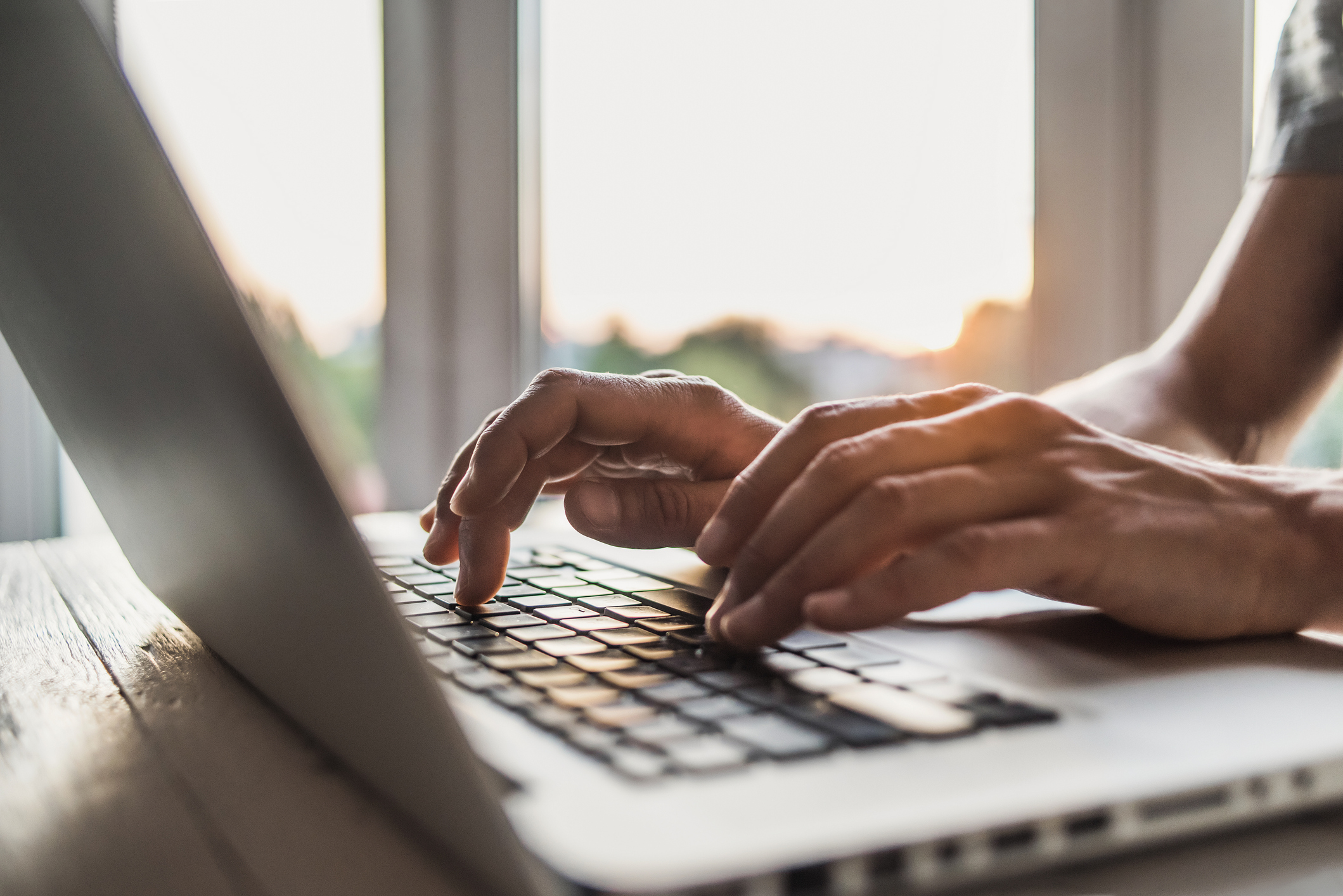 Man using laptop computer in the office Close up of hands typing on the laptop