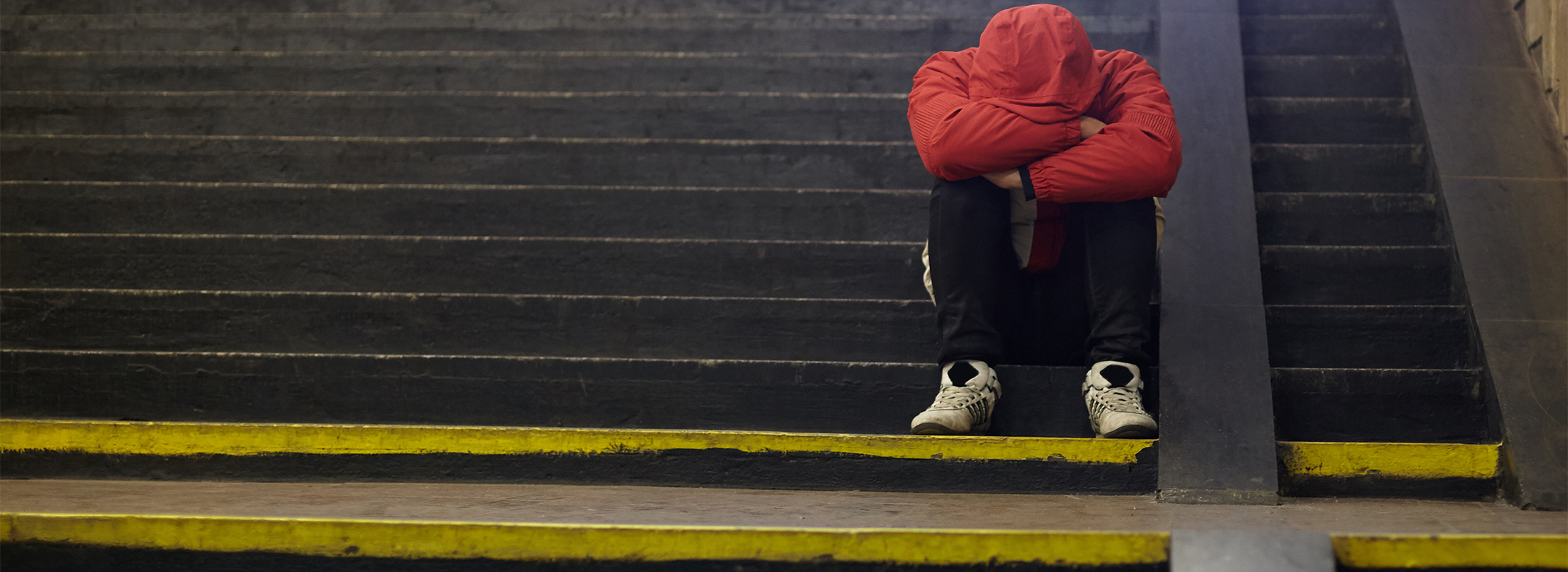 Youth sitting on steps in red jacket Youth sitting on steps in red jacket