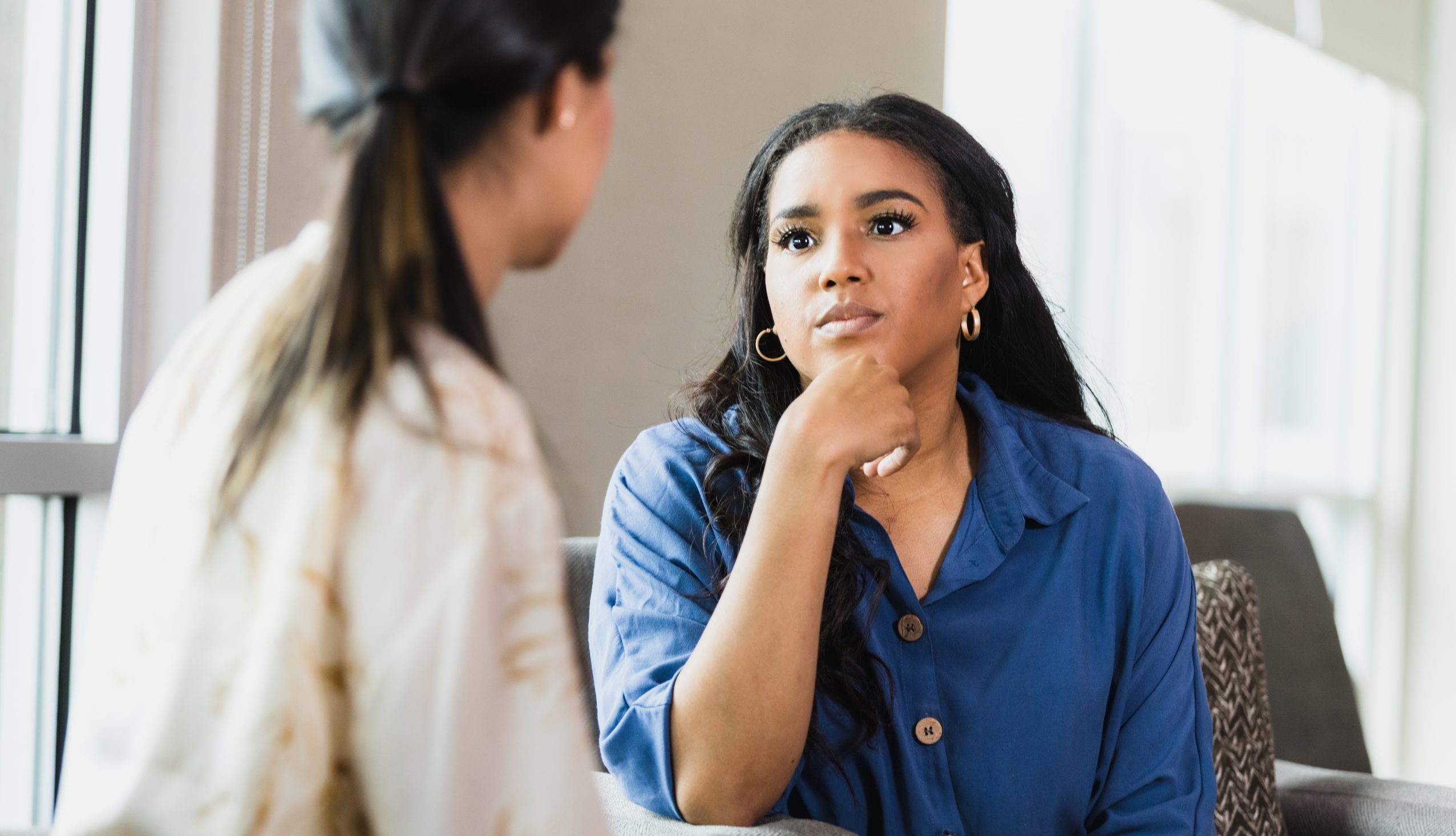 Two Women in Deep Conversation, Showing Empathy and Support Photo of two women sitting and talking, showing empathy and support.